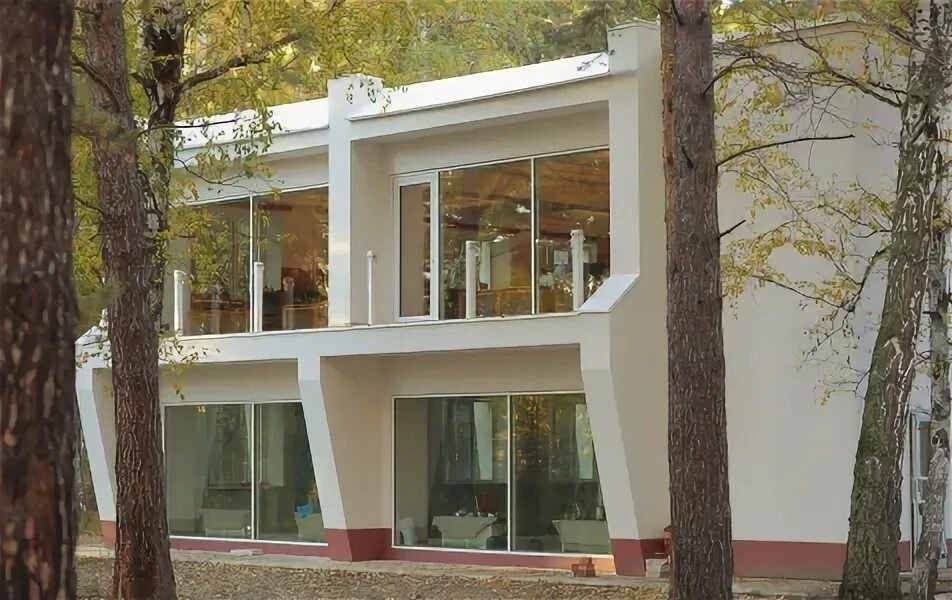 Светлый корпус Дома Пионеров среди сосен